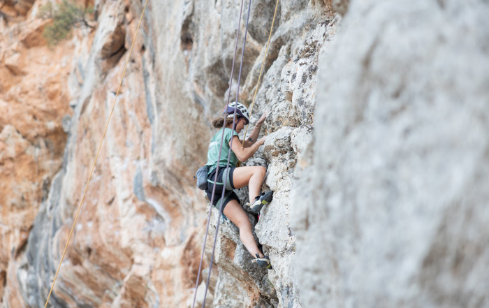 Mujer en pared haciendo escalada multilargo